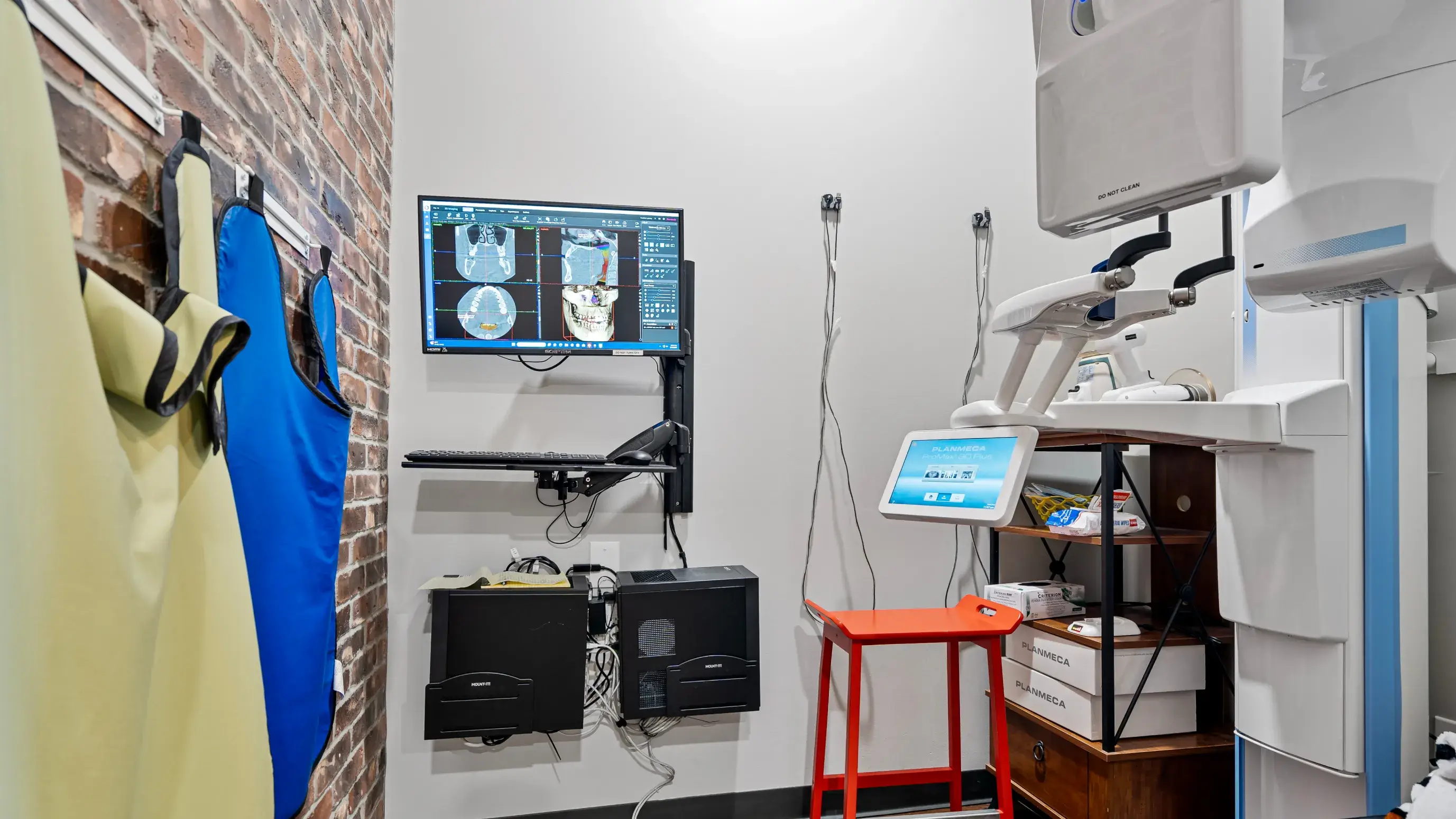 a medical room with a monitor and a chair