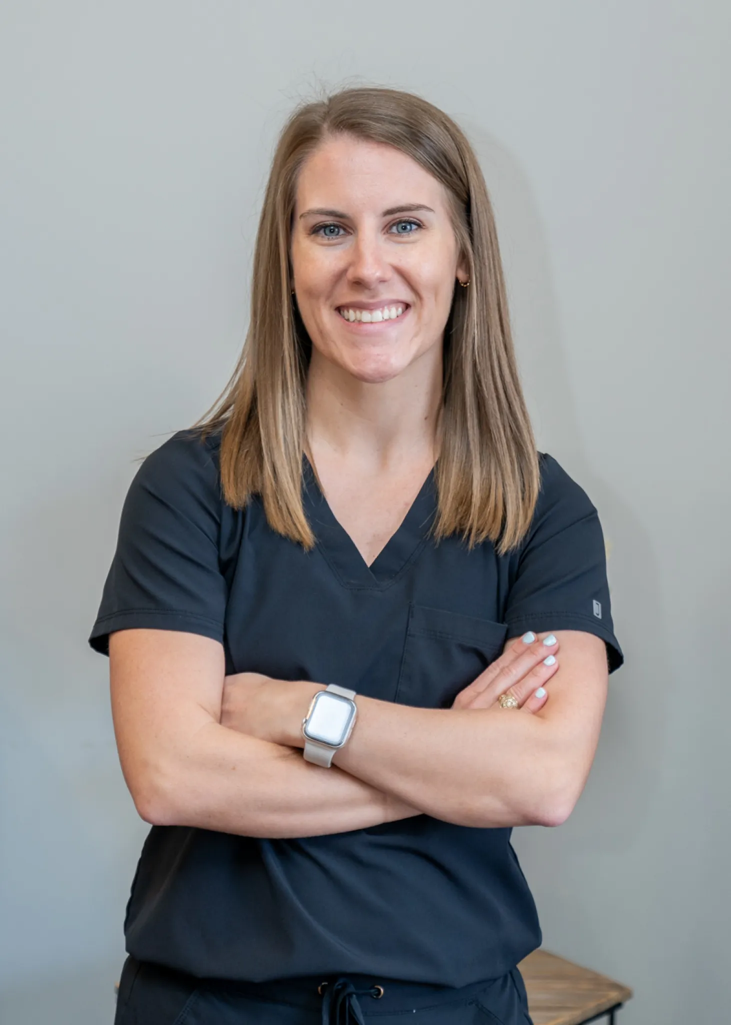 a woman in scrubs with her arms crossed