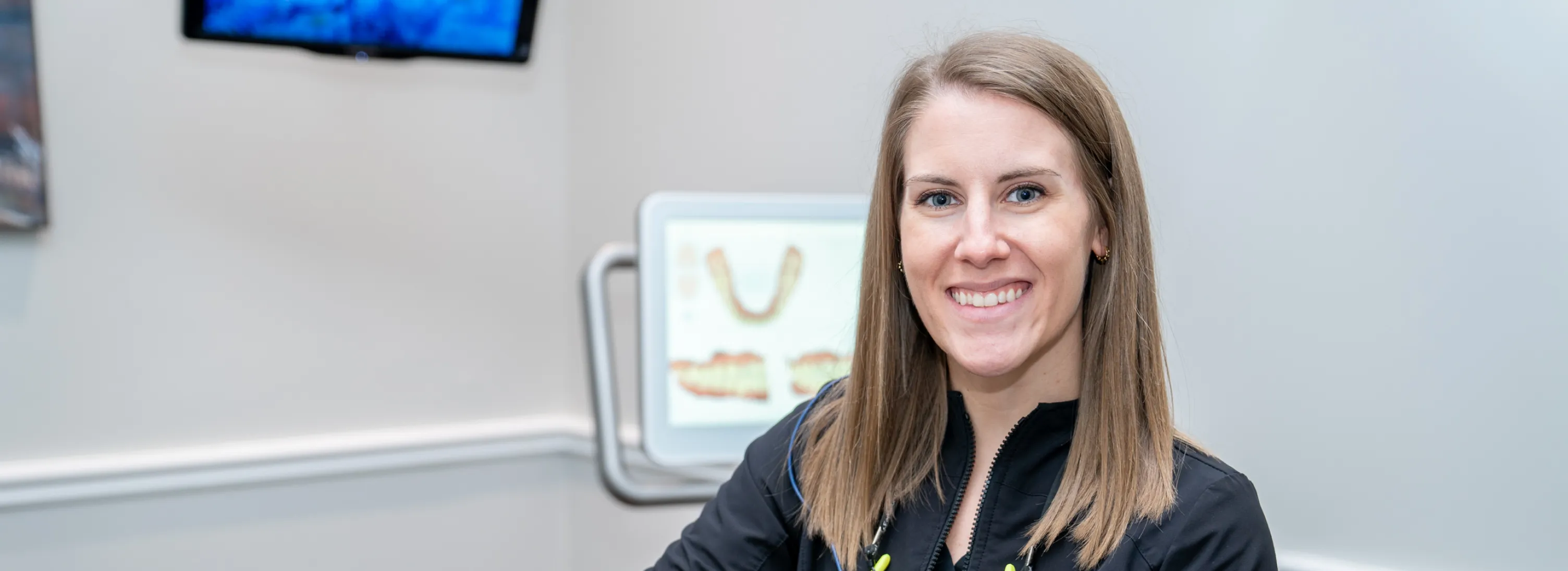 a woman sitting in a dental office smiling