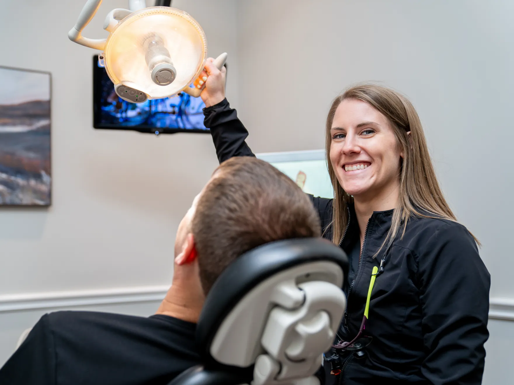 a woman sitting next to a man in a dentist chair