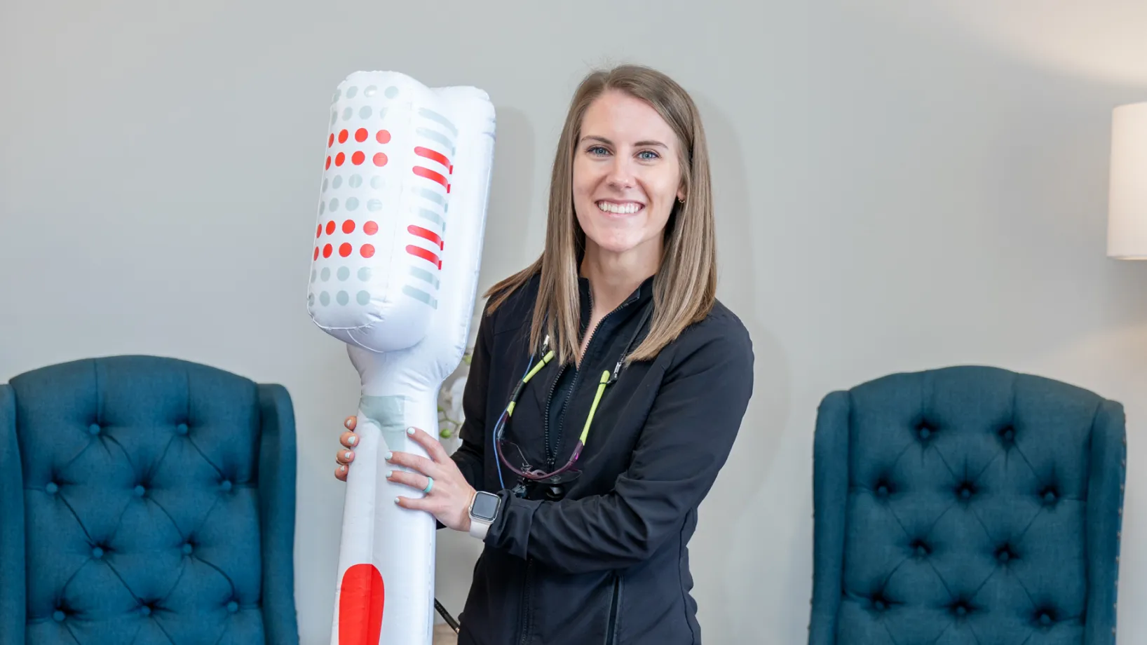a woman holding a giant blow dryer in her hands